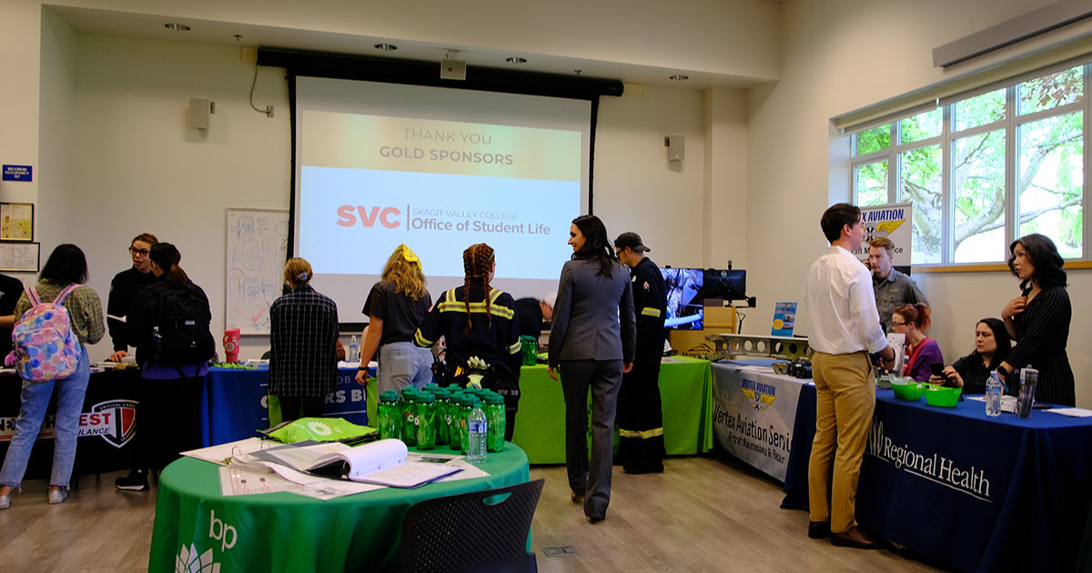 Event sponsors speaking with students.